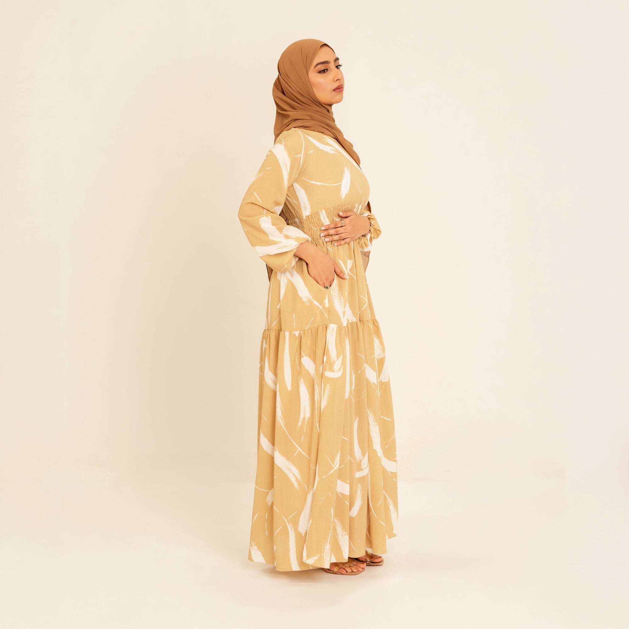 Noor champagne feather-print dress, three-quarter view showing the shirred waist